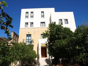 a white building with trees in front of it at Rivotorto Retreat House in Birkirkara
