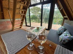 two glasses of wine sitting on a wooden table at La cabaña de puente palo in La Cumbre
