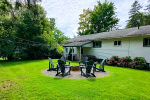 a yard with a house with a fire pit and chairs at Ultra Comfy, Spotless & Spacious, Private Home in Boyne, Dogs Ok, Walk to Town in Boyne City