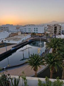 a large pool in a city with palm trees and buildings at Casa sofia in Argana