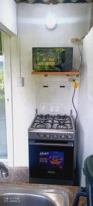 Una estufa en una cocina con un televisor encima. en La Escondida, 