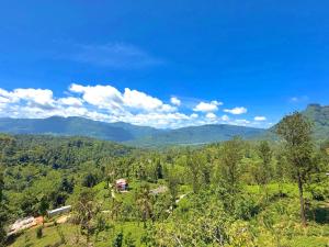 a house on a hill with mountains in the background at Vilona Inn in Dehintalawa