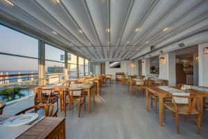 a restaurant with wooden tables and chairs and windows at Meis Exclusive Hotel in Kaş