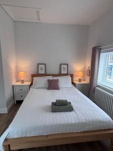 a bedroom with a large white bed with two lamps at 96 Roseberry Cottage in the market town of Guisborough in Guisborough