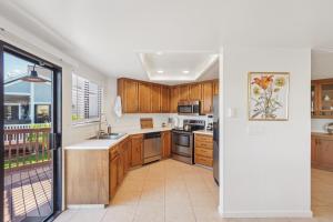 a kitchen with wooden cabinets and a large window at Waterfront Escape with Private Dock home in Discovery Bay