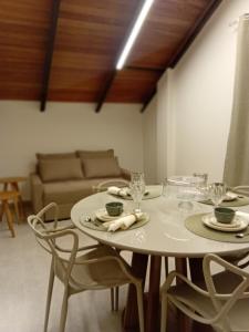 a table and chairs in a room with a couch at Loft Veneza in Santa Teresa