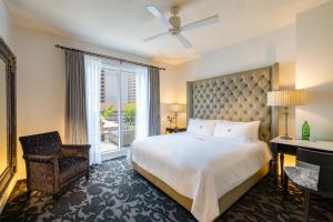 a bedroom with a bed and a chair and a window at International House Hotel in New Orleans +72 photos