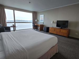 a hotel room with a large bed and a flat screen tv at Novotel Puerto Montt in Puerto Montt