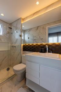 a bathroom with a toilet and a shower and a sink at Apto ALTO LUXO Atalaia - frente mar - Aracaju in Santa Maria