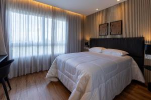 a bedroom with a white bed and a large window at Apto ALTO LUXO Atalaia - frente mar - Aracaju in Santa Maria +28 photos