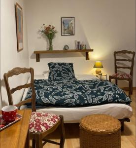 a bedroom with a bed and a table and chairs at La Maison d'Alienor - Les Montmains - Chablis 89 in Chablis