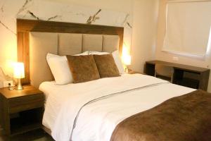 une chambre avec un grand lit blanc avec deux lampes dans l'établissement Hotel tierra del sol, à Uribia