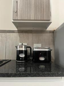 a kitchen counter with a toaster and a coffee maker at Modern Style Apartments, An Escape From The City in Pretoria +5 photos