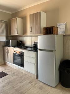 a kitchen with white appliances and a white refrigerator at Modern Style Apartments, An Escape From The City in Pretoria