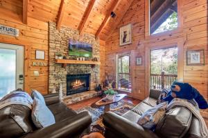 a living room with leather furniture and a fireplace at Sevierville Cabin with Deck Minutes to Pigeon Forge in Sevierville