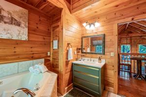 a log cabin bathroom with a tub and a sink at Sevierville Cabin with Deck Minutes to Pigeon Forge in Sevierville +36 photos