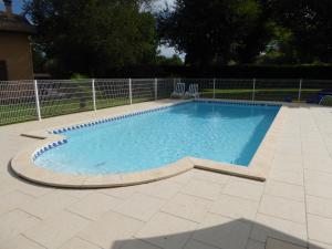 a large swimming pool in a yard with a fence at La Mimona in Sainte-Eulalie-en-Born