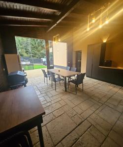 a large patio with a wooden table and chairs at IUNIk in Azuga