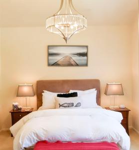 a bedroom with a large bed with a chandelier at Stunning Oceanview Townhouse Walk to Seawall, Shops & Depoe Bay Dining in Depoe Bay +91 photos
