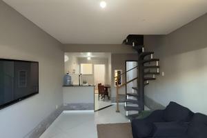 a living room with a spiral staircase and a television at Duplex em Itaúna 4min da Praia que ocorre o WSL, 1min da pista de skate do LS, pracinha com parque infantil, quadra de futebol, tudo isso a 1 min da duplex, perto do comércio, wi-fi super rápido, estacionamento gratuito, monitoramento 24hrs in Saquarema