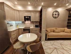 a kitchen with a table and a couch in a room at Двухкомнатная квартира студия in Almaty +10 photos