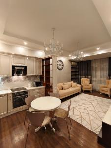 a large kitchen with a table and a couch at Двухкомнатная квартира студия in Almaty