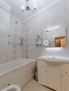 a bathroom with a sink and a tub and a toilet at Двухкомнатная квартира студия in Almaty