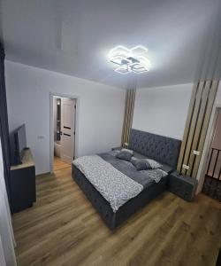 a bedroom with a large bed and a light at IUNIk in Azuga