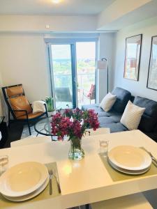 a living room with a table with a vase of flowers at Lakeview Steps to the lake & just minutes to downtown in Toronto