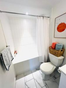 a bathroom with a toilet and a bath tub at Lakeview Steps to the lake & just minutes to downtown in Toronto +12 photos