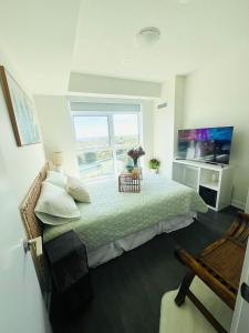 a bedroom with a bed and a large window at Lakeview Steps to the lake & just minutes to downtown in Toronto