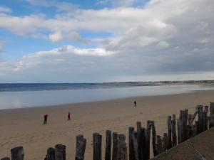a group of people walking on the beach at Saint Malo - Chambre cocooning- A la campagne in Saint Malo