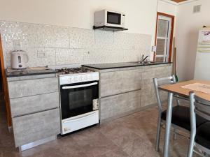 una cucina con piano cottura e tavolo di Casa M&M a Puerto Madryn