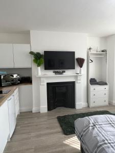 a white room with a fireplace with a tv on top at 1st Floor 1 Bed Studio in Weston-super-Mare