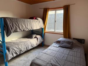 una camera da letto con due letti a castello e una finestra di Casa M&M a Puerto Madryn Altre 2 foto
