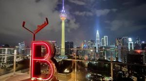 Blick auf eine Stadt in der Nacht mit der Raumnadel in der Unterkunft Ceylonz Suites, Bukit Bintang, Kuala Lumpur in Kuala Lumpur