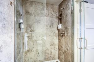 a shower with a glass door in a bathroom at Bay Suites Studio A Modern Coastal Escape in the Heart of Depoe Bay in Depoe Bay +20 photos