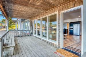 an empty porch of a house with a bench at Bay Suites Studio A Modern Coastal Escape in the Heart of Depoe Bay in Depoe Bay