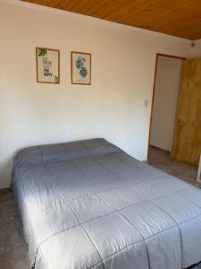 un letto in una camera con due immagini sul muro di Casa M&M a Puerto Madryn