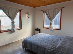 una camera da letto con un letto e due finestre di Casa M&M a Puerto Madryn