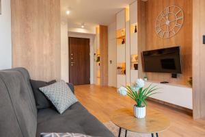 a living room with a couch and a table at Luxury Apartment Mennica Residence strefa wellness and sport by P&M in Warsaw