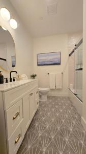 a white bathroom with a sink and a toilet at 2BR Apt with Parking Garden View Walk to Waterfront in Providence