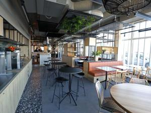 a restaurant with tables and chairs in a room at Ibis Bourgoin Jallieu Medipole in Bourgoin