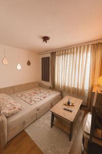 a bedroom with a bed and a coffee table at Apartman Rejjan in Zenica