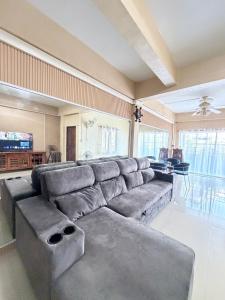 a large living room with a large gray couch at House near Central Festival Hatyai in Hat Yai