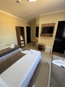 a hotel room with two beds and a flat screen tv at Aeroporto Plaza Hotel in Campo Grande