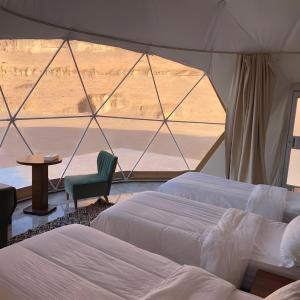 a bedroom with two beds and a view of the desert at Volta Desert Camp in Wadi Rum +56 photos