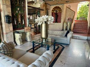 阿瓜斯卡连特斯加莱里亚斯酒店的大厅里摆放着沙发，桌子上放着插着鲜花的花瓶