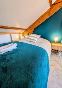 a bedroom with a large bed with a blue wall at Maison cozy plage & jardin in Saint-Brevin-les-Pins