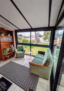 a living room with two chairs and a couch at Maison cozy plage & jardin in Saint-Brevin-les-Pins